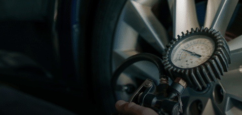 Termometer viser 7 grader og bil med vinterdæk på snedækket vej